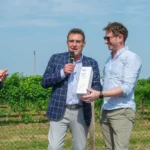 Alt text: Evento vitivinicolo con premiazione Prosecco DOCG tra i vigneti di Conegliano Valdobbiadene.