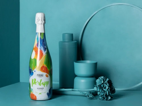 perlage-v-come-vegani Bottiglia di Prosecco DOCG biologico Perlage su sfondo turchese, simbolo di eccellenza del Conegliano Valdobbiadene.